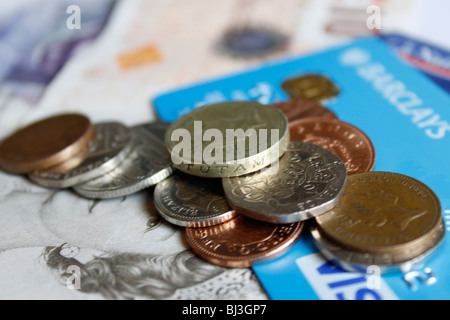 Nahaufnahme von Sterling Münzen auf Bankkarten und Sterling Notizen Stockfoto