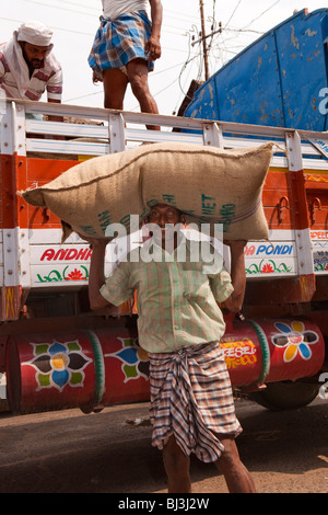 Indien, Kerala, Calicut, Kozhikode, Big Bazaar Mann entladen Säcke von Gewürzen aus LKW Stockfoto