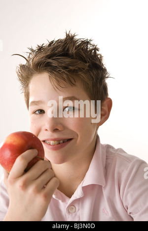 Eine lächelnde junge, einen roten Apfel in der hand Stockfoto