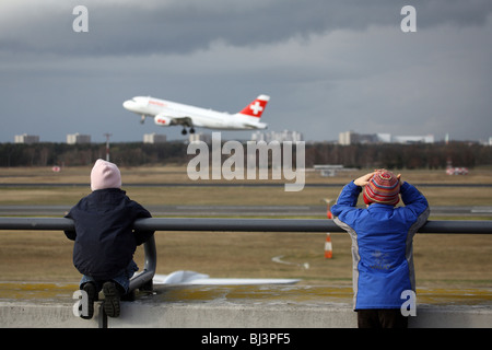 Kinder beobachten eine SwissAir-Flugzeug abheben, Berlin, Deutschland Stockfoto