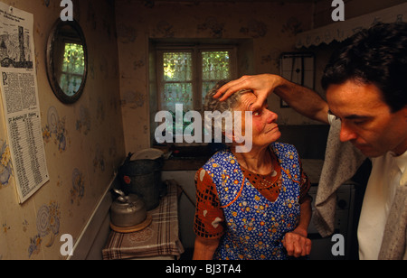 In der Privatsphäre ihres eigenen Landes zu Hause ist eine alte französische Dame etwa Augentropfen verabreicht durch ihren Hausarzt. Stockfoto