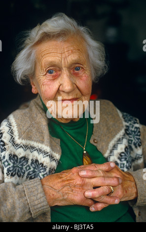 Eine 90-jährige sitzt mit Daumen auf Betrachter mit einem milden Blick der milden Verblüffung und Traurigkeit. Stockfoto