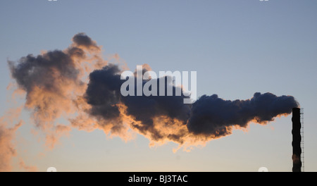 Rauch aus einem Fabrikschornsteinen am Abend Stockfoto