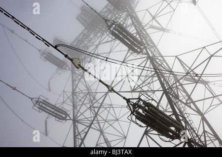 Pylon Elektrokabel erstrecken sich in frühen Morgennebel über Swanscombe, Kent. Stockfoto