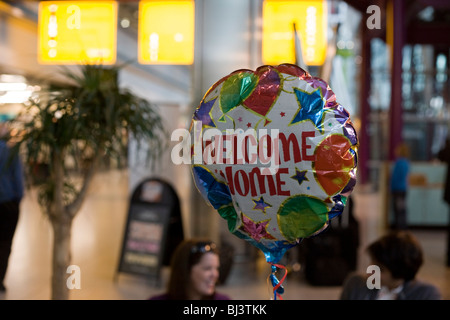 Welcome Home heliumgefüllten Ballon schwebt in der Luft in der Ankunftshalle des Flughafens Heathrow Terminal 5. Stockfoto