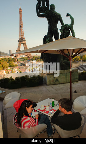 Paris, Frankreich, Paar von hinten, im French Cafe Bistro Restaurant, Terrasse auf dem Bürgersteig, mit Blick auf den Eiffelturm, Bier am Tisch teilen, Straßencafé-Szene, pariser Bistrotisch, FRAU TRINKT DRAUSSEN IM PUB, Skulptur dahinter Stockfoto