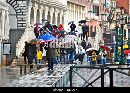 Menschen, die zu Fuß entlang erhoben Gehwege bei Hochwasser, Acqua Alta in Venedig, Veneto, Italien Stockfoto