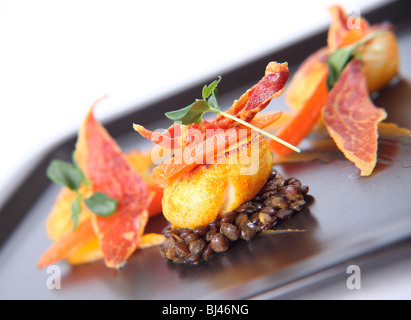 Trio von Jakobsmuscheln auf Curry Linsen, Butternut-Kürbis-Püree und knusprigem Parmaschinken Stockfoto