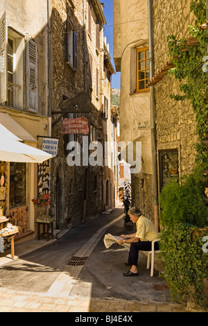 Provence, Frankreich - Vence, Côte d Azur, Europa - Altstadt shop besitzer liest Zeitung in der Provence, Frankreich Stockfoto