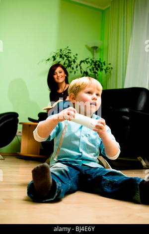 Junge spielt mit einer Spielkonsole im Wohnzimmer Stockfoto