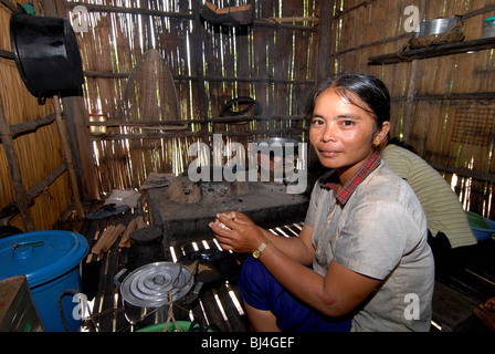 Frau Kaminfeuer in einer Küche in ihrer Hütte, Phum Chikha, Kambodscha Stockfoto