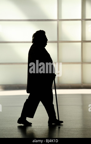 Silhouette einer älteren Frau mit dem Rohrstock Stockfoto