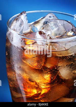 Glas Cola Eis auf blauem Hintergrund Stockfoto