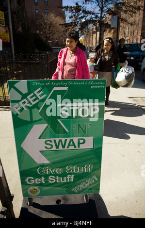 Sparsame Käufer bringen unerwünschte Gegenstände auf eine Haltestelle des kostenlosen ' n ' Swap-Veranstaltung im Stadtteil Jackson Heights in Queens in New York Stockfoto