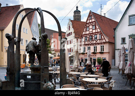 Reich verzierten Brunnen mit Skulptur und Außenbereich des Restaurants auf Straße, Nordlingen, Bayern, Deutschland Stockfoto