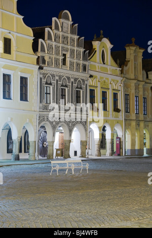 Beleuchtete Stadt Häuser mit Arcade auf dem Platz in Telc, Böhmen - Tschechien, mit leeren Bank während der Dämmerung. Stockfoto
