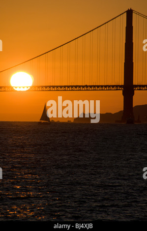 Sonnenuntergang hinter der Golden Gate Bridge und ein Segelboot, San Francisco, Kalifornien, USA Stockfoto