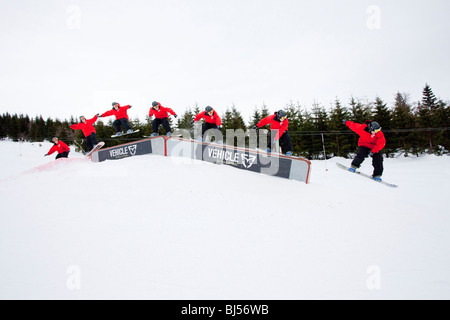 Mann Snowboarding, die Folge von vielen Schüssen. Ein Mann in einer roten Jacke ist Snowboarden auf einer Rampe. Bedeckt. Stockfoto