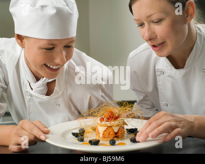 Zwei weibliche Köche bewundern eine pudding Stockfoto