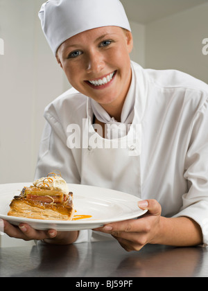 Eine Köchin halten eine Konditorei-Wüste Stockfoto