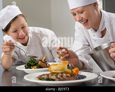 Zwei weibliche Köche beenden einige Abendessen Stockfoto