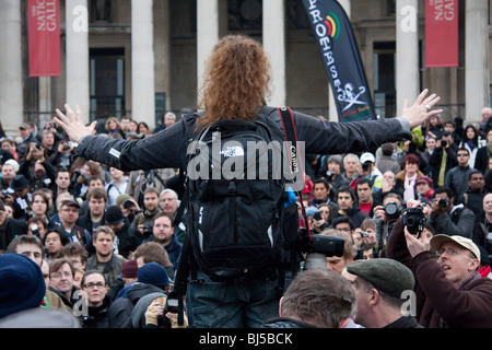 Junge Frau Fotograf ausgestreckte Armen befasst sich eine Demonstration des Fotografen auf dem Trafalgar Square Stockfoto