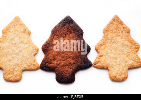 Drei Zimt Weihnachtsbaum geformt Cookies, einer verbrannt Stockfoto