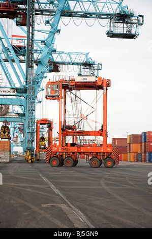 Orange Straddle Carrier Kran zum Heben von Schiffe Containern im Hafen Stockfoto