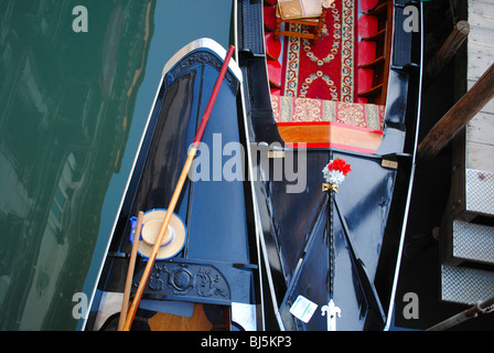 Ein Gondoliere Hut und Ruder liegen an Bord seine Gondel in einem Kanal in San Lio, Venedig, Italien Stockfoto