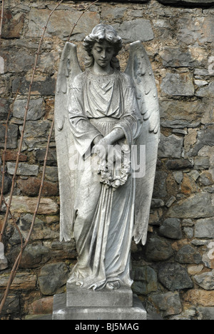 Statue eines Engels hält einen Kranz in der Dean Friedhof Edinburgh, Schottland. Stockfoto