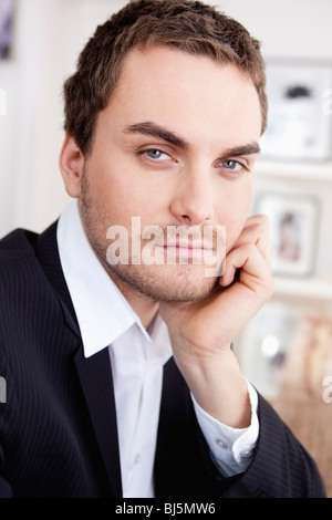 Ernst aussehender Mann ruht Kinn auf Seite Stockfoto