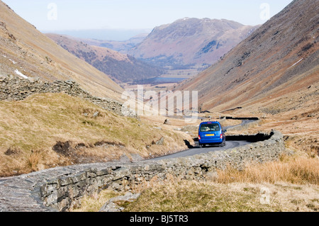 Ein Auto absteigend den Kirkstone Pass Richtung Brüder Wasser im englischen Lake District Stockfoto