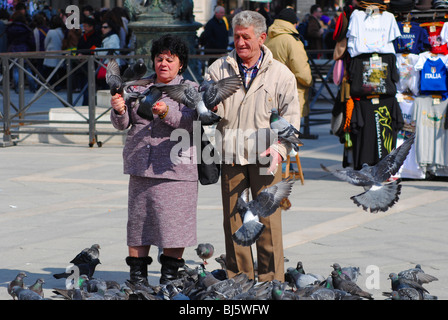 Touristen füttern Tauben in Markusplatz entfernt, Venedig, Italien Stockfoto