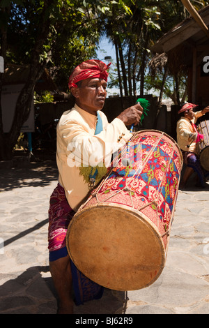 Indonesien, Lombok, Sade, traditionellen Sasak Village, Mann, Trommeln, Besuch Partei von Touristen begrüßen zu dürfen Stockfoto