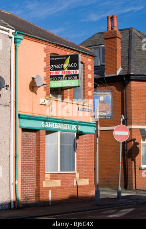 Mit Brettern vernagelt und heruntergekommen Stammkneipe der GARIBALDI Hotel Garni zum Verkauf an einer Straßenecke in der Innenstadt von Swansea South Wales UK Stockfoto