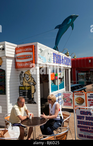 Großbritannien, England, Norfolk, Hembsby, Beach Road, paar am Fish &amp; Chips Imbiss Stand in der Sonne sitzen Stockfoto