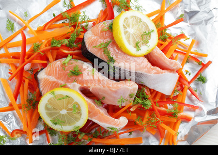 Roher Lachs Steaks mit Zitrone und Gemüse auf einer Folie Stockfoto