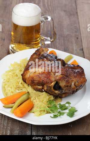 Eisbein mit Sauerkraut und Bier auf weißen Teller Stockfoto