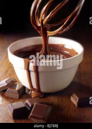 Geschmolzene Choclate wird in einer Schüssel - Stock Photos gerührt. Stockfoto