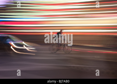 Ein Radfahrer durchfährt nachts die Lichter des Times Square in New York City. Stockfoto