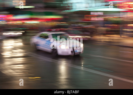 Bewegung verwischt Abstraktion des NYPD Polizeiauto Rauschen über den Times Square im Regen Stockfoto