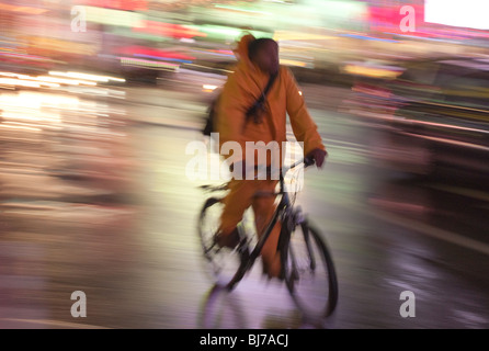 Ein Radfahrer durchfährt nachts die Lichter des Times Square in New York City. Stockfoto