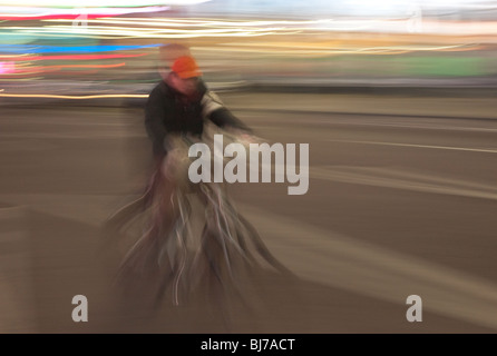 Ein Radfahrer durchfährt nachts die Lichter des Times Square in New York City. Stockfoto