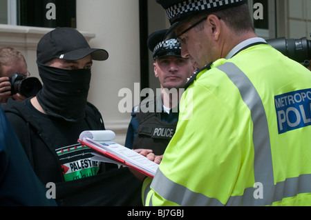 Polizist liest Warnung NoBorders Protest in der französischen Botschaft in London gegen Zerstörung von Calais Immigrant camps Stockfoto