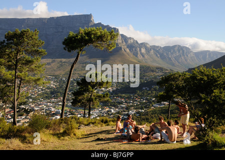 Gruppe von Jugendlichen sitzen mit Blick auf Tafelberg und die zwölf Apostel-Cape Town-Südafrika Stockfoto