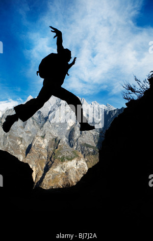 Trekker auf Tigersprung-Schlucht in der Provinz Yunnan, China in die Luft springen. Stockfoto