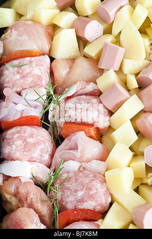 Detail von rohem Schweinefleisch Kebab mit in Scheiben geschnittenen Kartoffeln, Würstel und Rosmarin Stockfoto