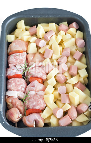 Detail von rohem Schweinefleisch Kebab mit in Scheiben geschnittenen Kartoffeln, Würstel und Rosmarin Stockfoto