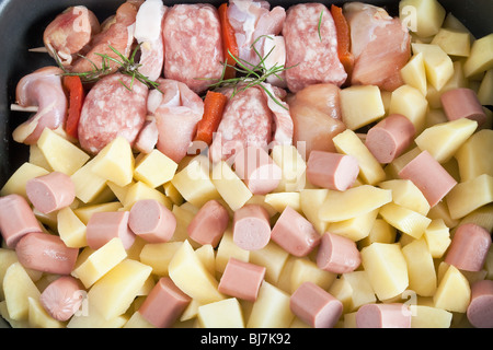 Detail von rohem Schweinefleisch Kebab mit in Scheiben geschnittenen Kartoffeln, Würstel und Rosmarin Stockfoto