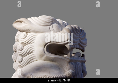 Schneiden Sie aus. Weißer Marmor chinesischen Fu Löwe Skulptur auf grauem Hintergrund. Stockfoto